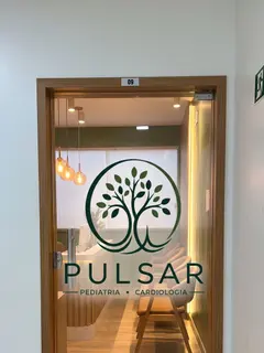 Porta de vidro da sala 09 com o logotipo da Clínica Pulsar aplicado.